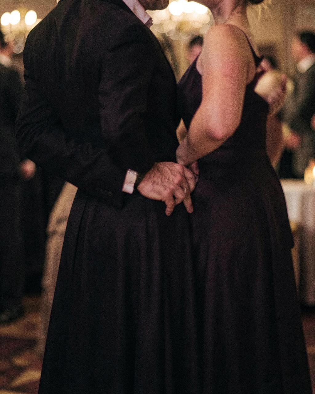Een hand op de onderrug van een vrouw in avondjurk