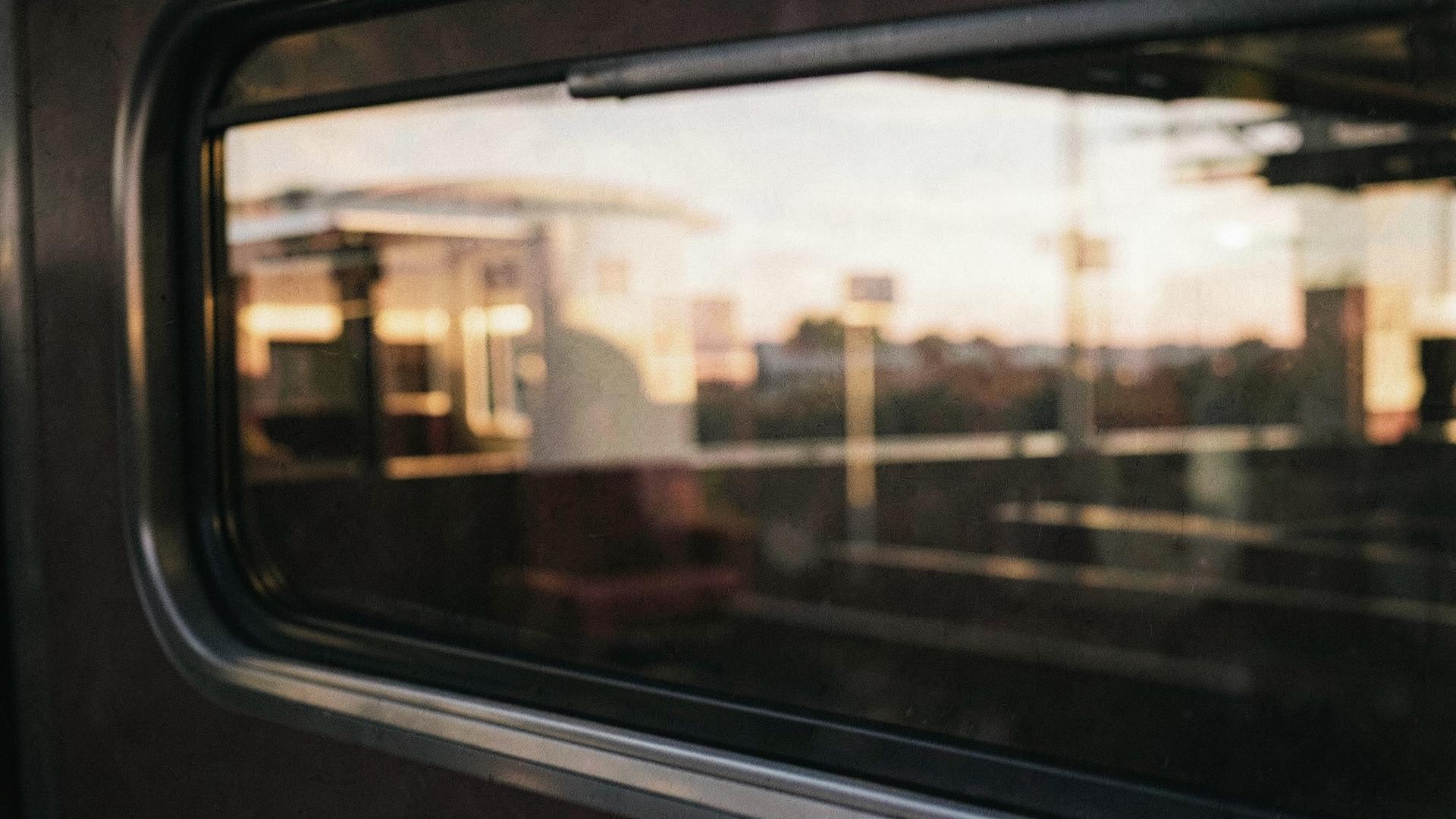 Treinraam met voorbijglijdend landschap in avondlicht