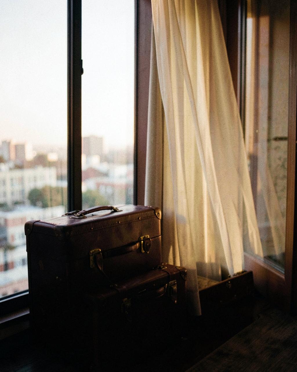 Koffers in een hotelkamer met uitzicht op de stad